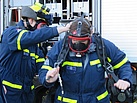 Atemschutzgeräteträger des THW unterstützen sich gegenseitig beim Anlegen der Ausrüstung.