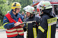 Einsatzleiter der Feuerwehr Schuld Sebastian Heinrich (Mitte) bespricht mit dem Zugführer des THW Ahrweiler Thomas Wruck (r.) die weiteren Maßnahmen.