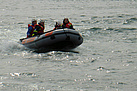 Teilnehmer des Jugendcamps jagen mit einem Schlauchboot über die Wellen.