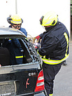 Ein THW-Helfer unterstützt einen Feuerwehrmann bei dem Zerschneiden eines Fahrzeugteiles.
